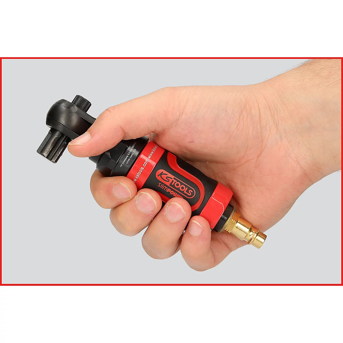 Person hält einen roten und schwarzen Druckluftratschenschrauber in der Hand.